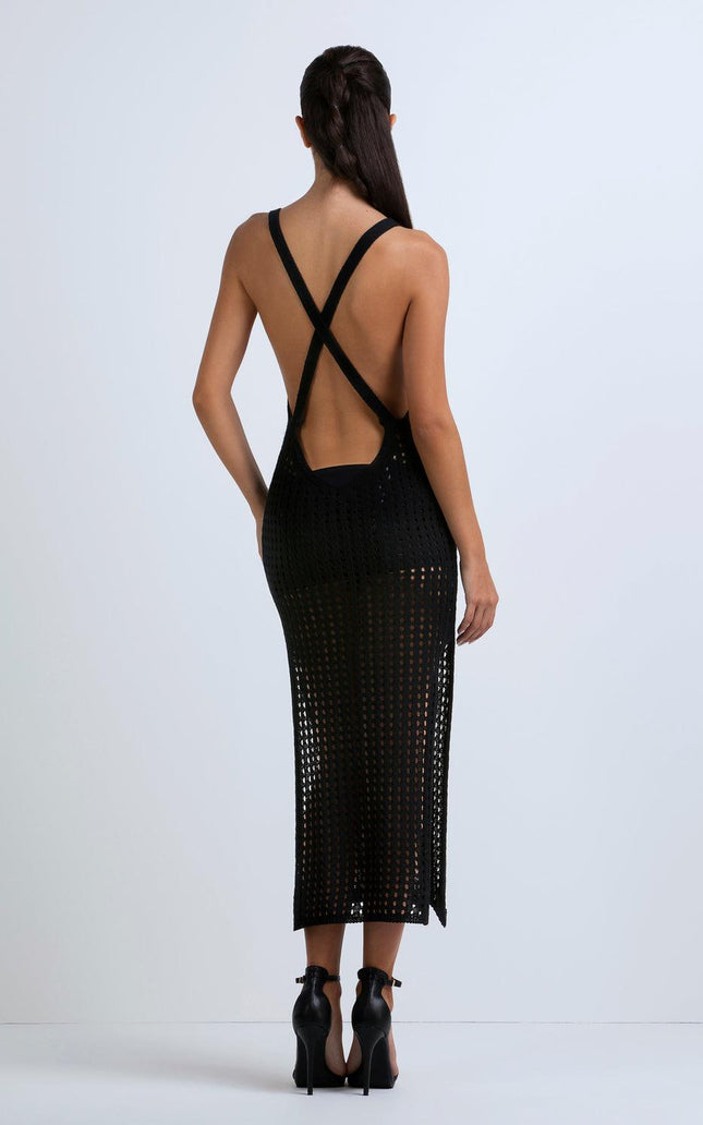 Woman in black open-back mesh dress with crisscross straps and high heels, rear view