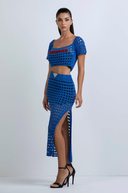 Woman in blue crochet crop top and matching high-slit midi skirt, modern fashion look