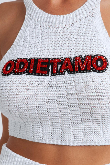 White knit crop top with red and black ODIE ET AMO sequin logo detail, close-up view