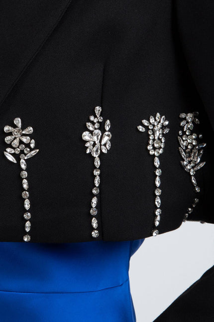 Black jacket with crystal floral embellishments over a blue dress