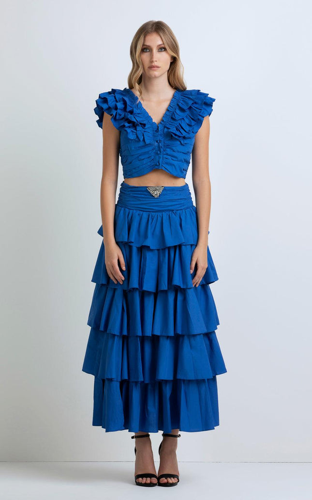 Woman wearing a vibrant blue ruffled crop top and tiered maxi skirt set