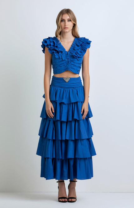 Woman wearing a vibrant blue ruffled crop top and tiered maxi skirt set