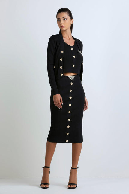 Woman wearing a black ribbed three-piece set with gold buttons and rhinestone accents