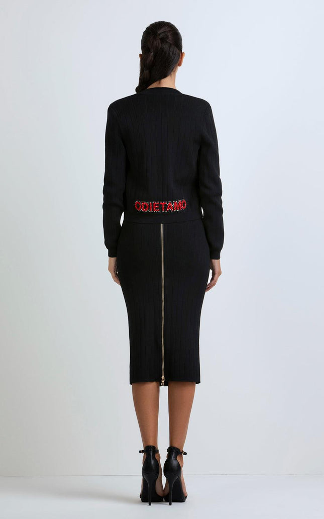 Woman wearing a fitted black ribbed midi dress with back gold zipper and red Odi et Amo lettering