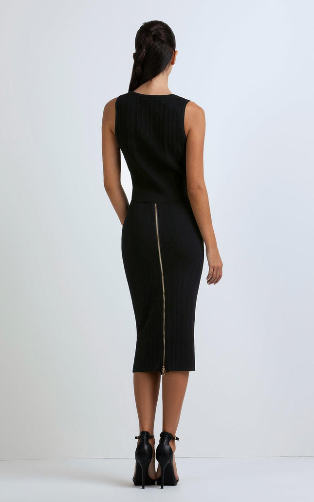 Woman in sleeveless black ribbed dress with visible back zipper and black high heels