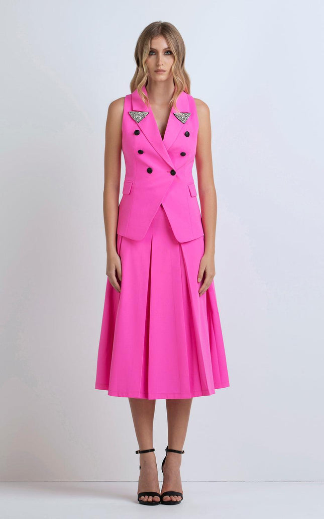 Woman wearing a sleeveless hot pink blazer dress with pleated skirt and crystal embellishments