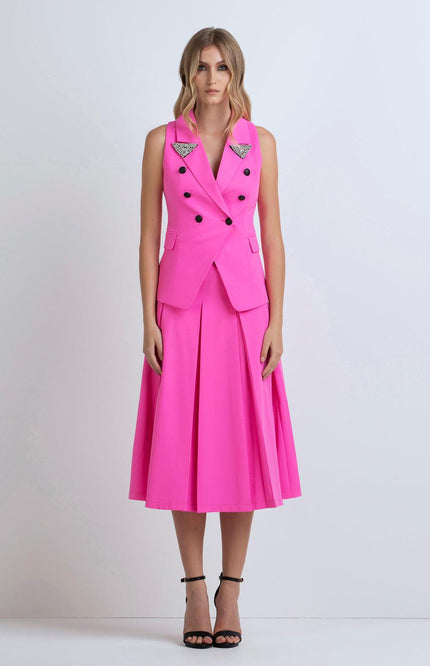 Woman wearing a sleeveless hot pink blazer dress with pleated skirt and crystal embellishments