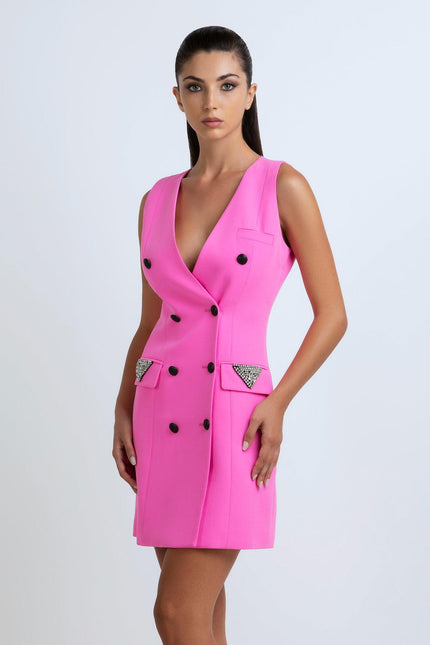 Woman wearing a sleeveless hot pink double-breasted dress with deep V-neck and jeweled pockets