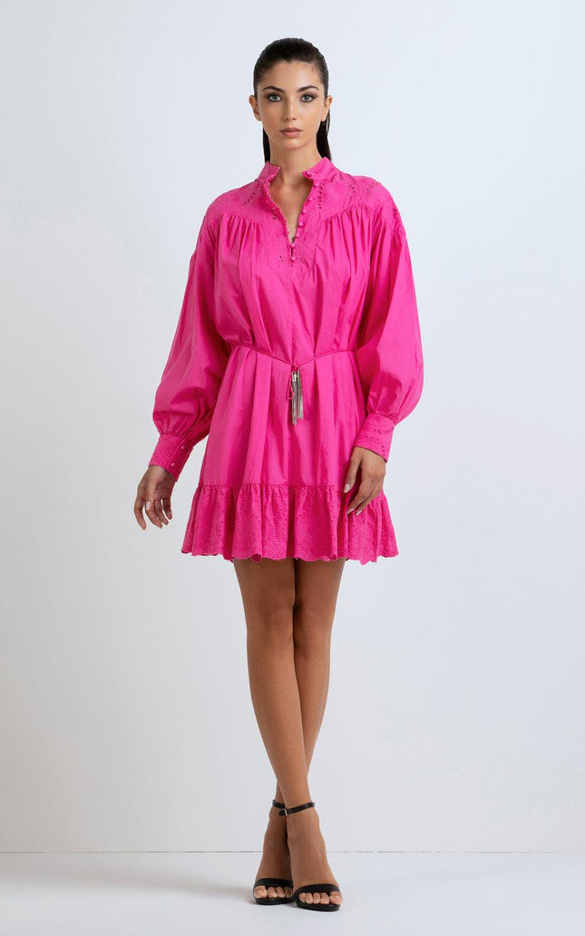 Woman wearing a hot pink mini dress with long sleeves, ruffle hem, and eyelet details