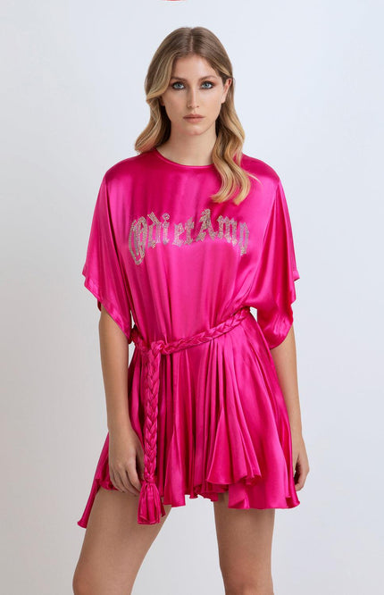 Woman wearing a hot pink satin mini dress with braided belt and crystal lettering