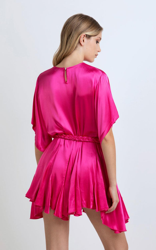 Back view of woman in vibrant pink satin mini dress with belt and flowy skirt