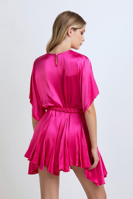 Back view of woman in vibrant pink satin mini dress with belt and flowy skirt