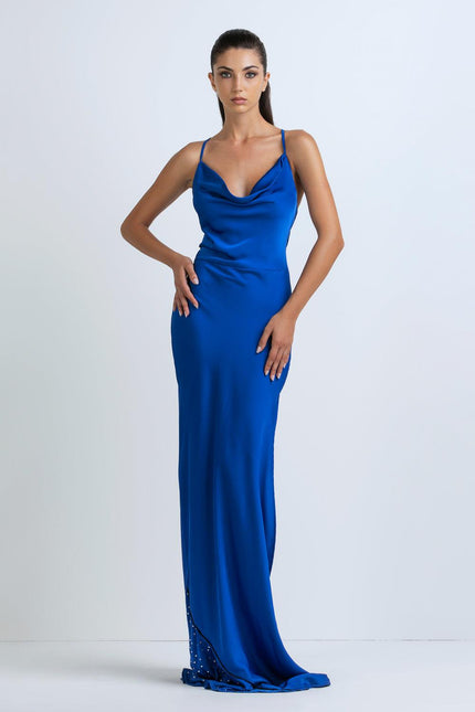 Woman wearing a long blue satin slip dress with thin straps, fashion photoshoot