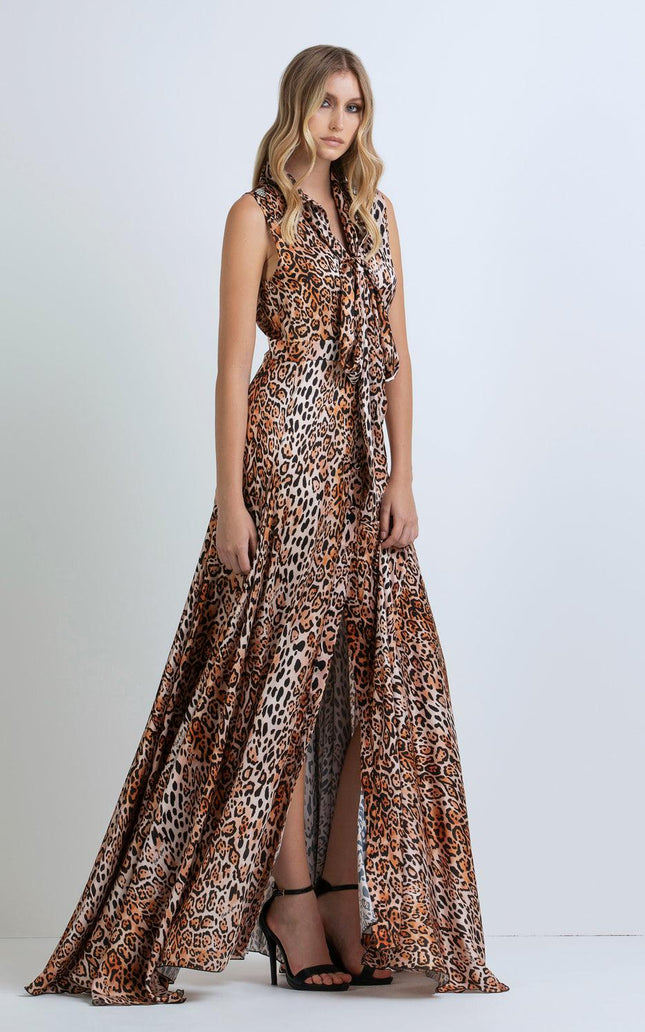 Woman wearing sleeveless leopard print maxi dress with front slit and black heels