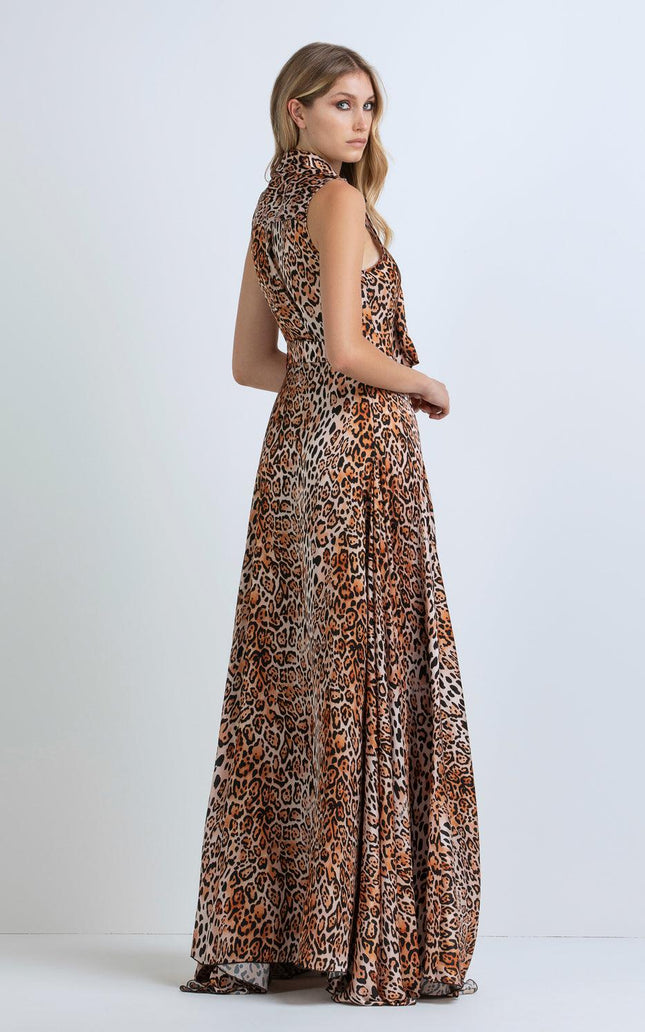 Woman wearing a sleeveless leopard print maxi dress, side view