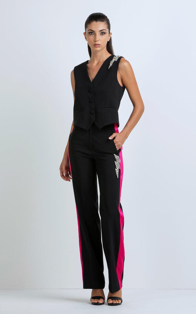 Woman wearing black vest and pants with pink side stripes and silver sequin accents