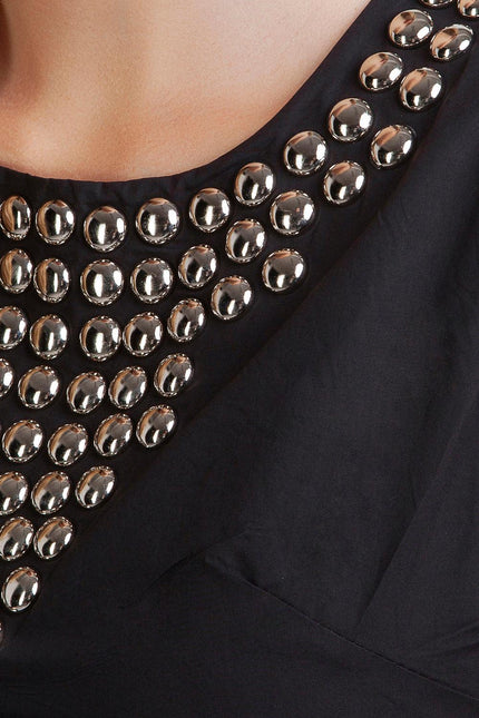 Close-up of black dress with metallic studded neckline detail