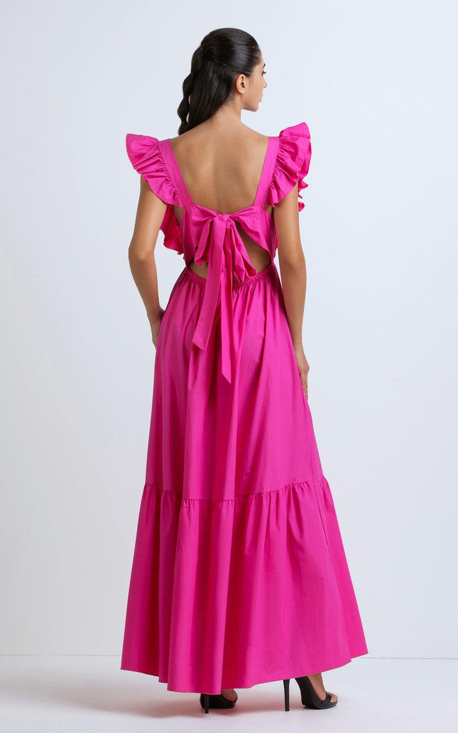 Woman in bright pink maxi dress with ruffled sleeves and open back bow detail