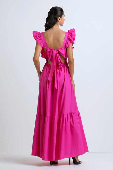 Woman in bright pink maxi dress with ruffled sleeves and open back bow detail