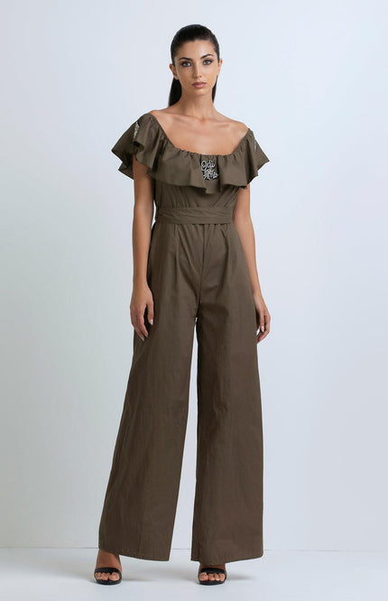 Woman wearing an olive green off-shoulder jumpsuit with ruffle detail and wide-leg pants
