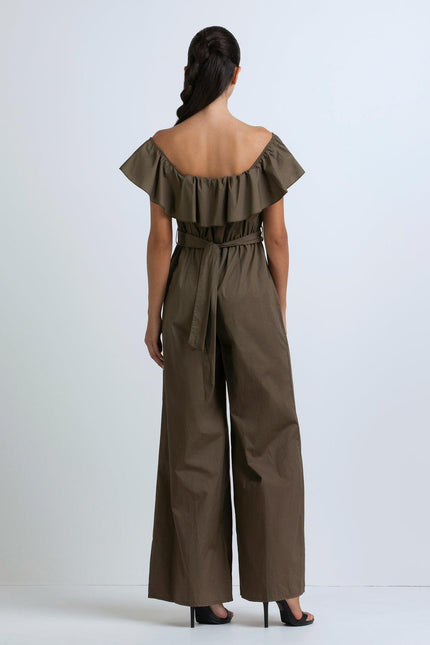 Woman wearing off-shoulder olive jumpsuit with ruffle neckline and wide-leg pants