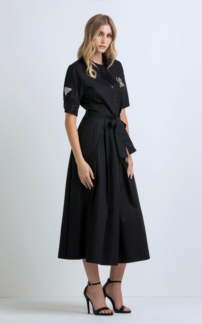 Woman wearing a black midi shirt dress with short sleeves and sash belt, fashion look