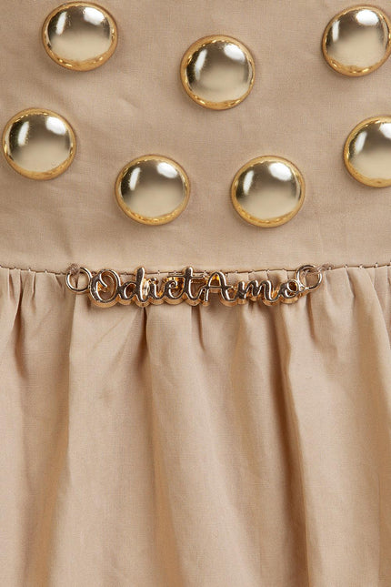 Beige dress with gold dome studs and metallic script detail on gathered fabric