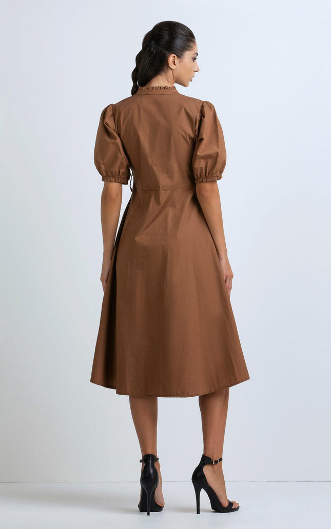 Back view of woman wearing brown puff sleeve midi dress and black high heels
