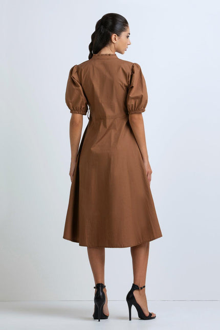 Back view of woman wearing brown puff sleeve midi dress and black high heels