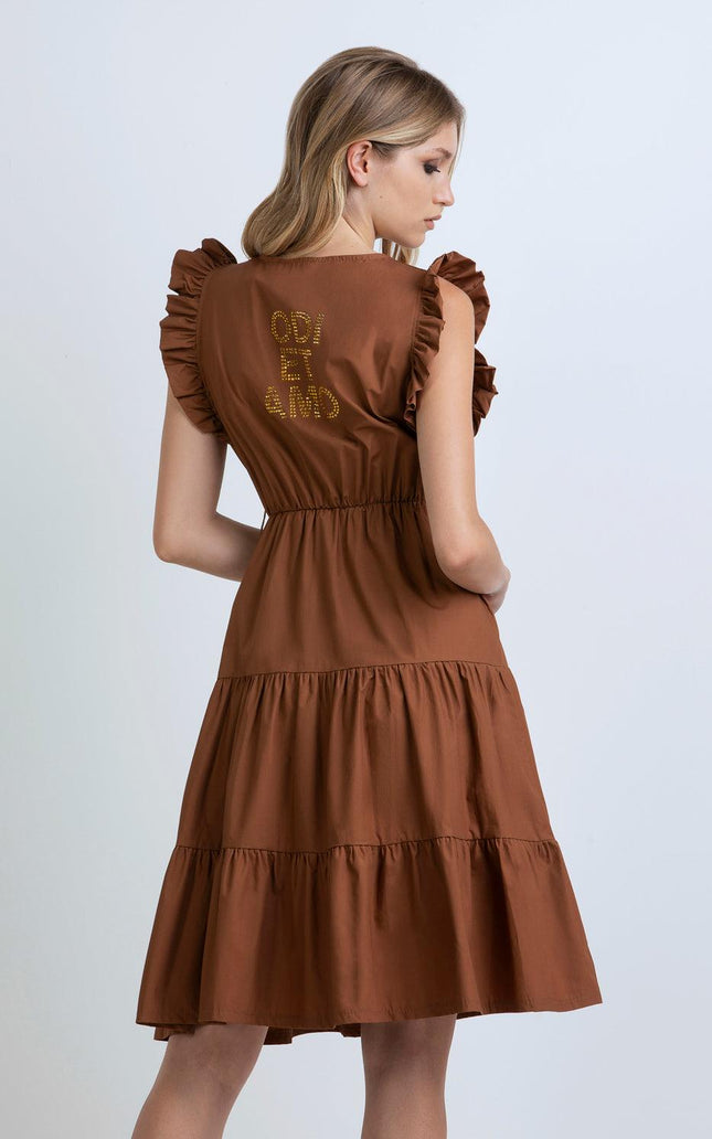 Woman wearing brown ruffled midi dress with gold lettering on back, fashion outfit