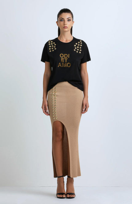 Woman in black studded t-shirt and beige ribbed skirt with front slit, fashion outfit