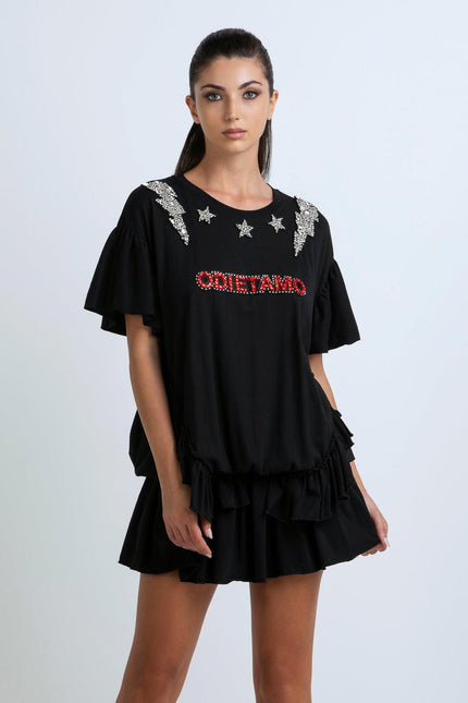 Woman wearing black embellished dress with ruffle sleeves and star details