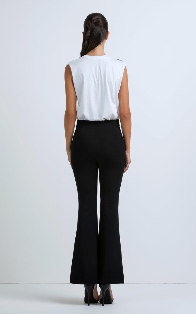 Woman wearing sleeveless white top and high-waisted black flared pants, back view