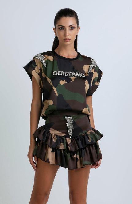 Woman wearing camouflage ruffle skirt set with crystal accents and bold lettering detail