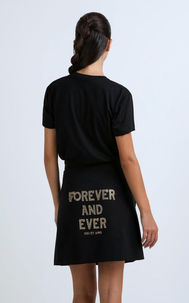 Woman in black short-sleeve dress with 'Forever and Ever' gold text on skirt, back view