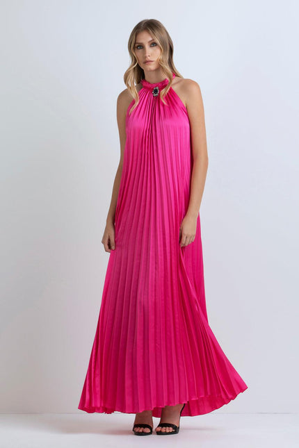 Woman wearing a pleated fuchsia maxi dress with halter neckline and jeweled detail