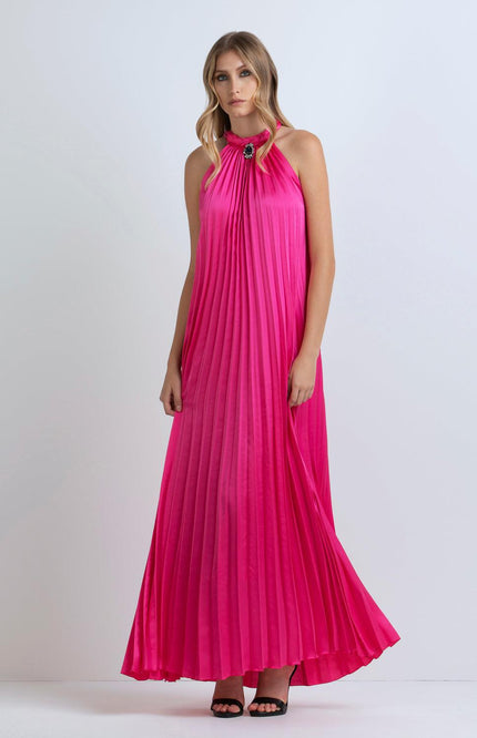 Woman wearing a pleated fuchsia maxi dress with halter neckline and jeweled detail