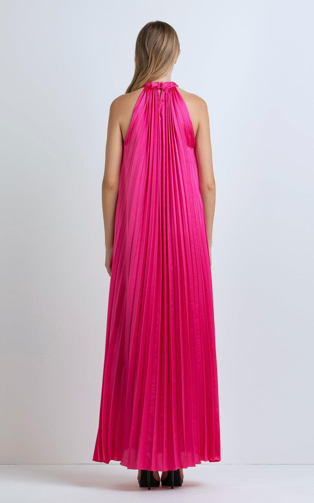 Woman wearing a sleeveless hot pink pleated maxi dress, back view, studio setting