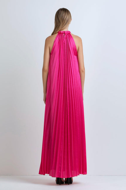 Woman wearing a sleeveless hot pink pleated maxi dress, back view, studio setting