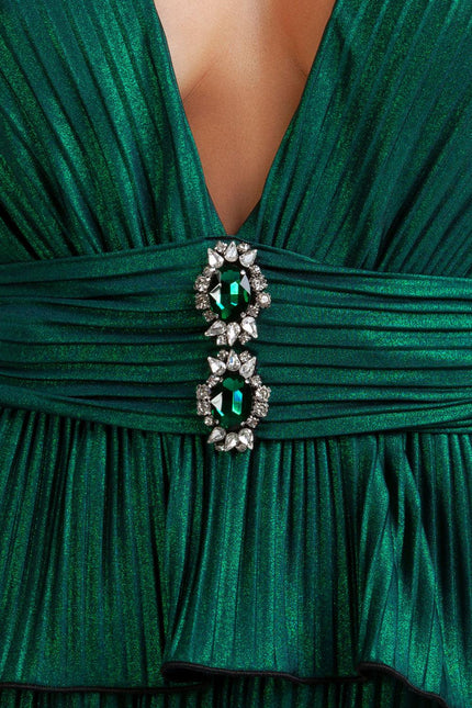 Close-up of pleated emerald green dress with deep V neckline and jeweled waist detail