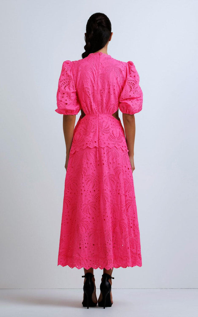 Woman in bright pink eyelet lace midi dress with puff sleeves, seen from the back