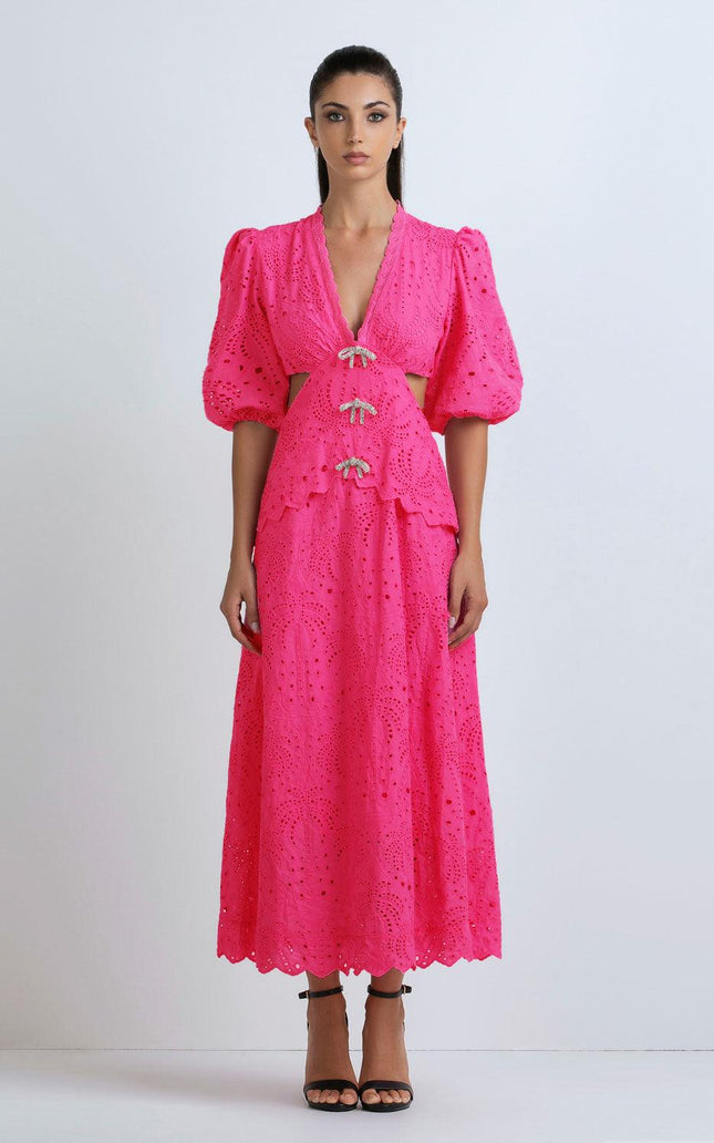 Woman in bright fuchsia eyelet maxi dress with puff sleeves and scalloped hem