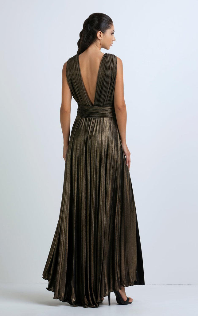 Woman wearing metallic pleated evening gown with deep V-back and high heels
