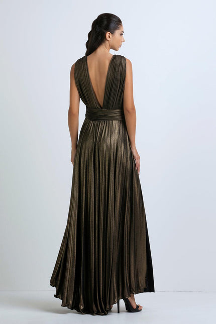Woman wearing metallic pleated evening gown with deep V-back and high heels
