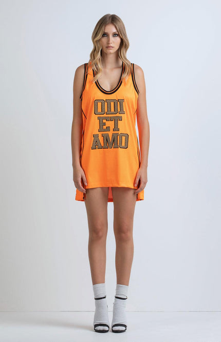 Woman wearing orange sleeveless mesh dress with bold lettering, sporty fashion style