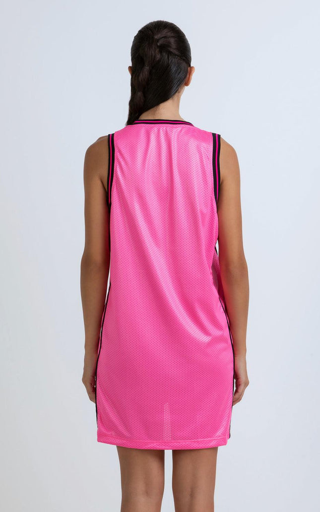 Woman wearing sleeveless pink mesh dress with black trim, back view, white background