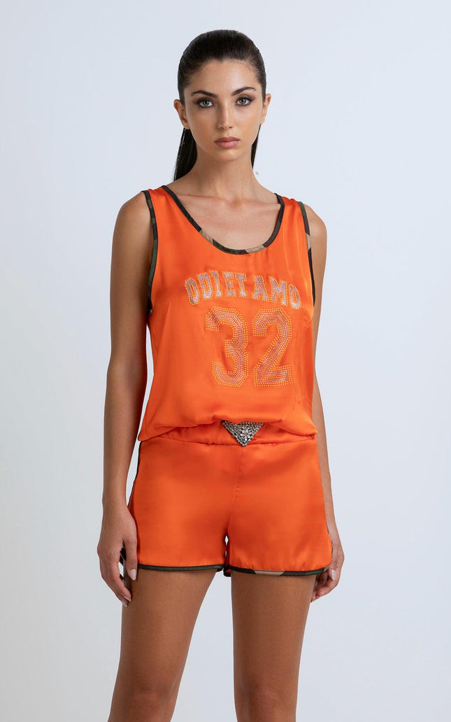 Woman wearing orange tank top and shorts set with 'ODI ET AMO 32' and rhinestone details