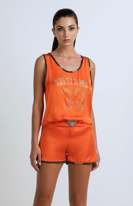 Woman wearing orange tank top and shorts set with 'ODI ET AMO 32' and rhinestone details
