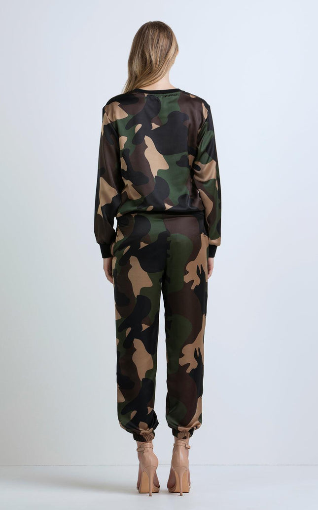 Woman wearing camouflage print tracksuit with long sleeves and pants, nude heels, back view