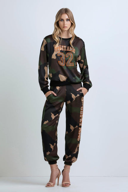 Woman wearing camo print tracksuit with crystal '32' detail and high heels, fashion look